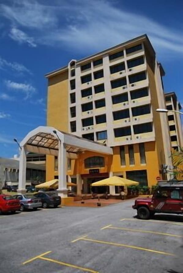 A multi-story hotel with a yellow facade, a covered entrance, and outdoor seating areas. - Klang Histana Hotel (Klang)
