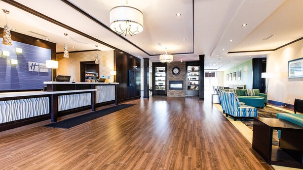 A spacious lobby with a reception desk, seating area, and a fireplace. - Holiday Inn Express & Suites Spruce Grove - Stony Plain by IHG (Spruce Grove)