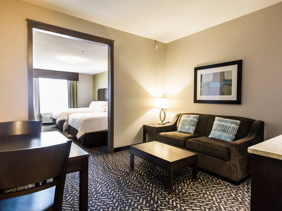 Een hotelkamer met een bed, een bank, een salontafel, een bureau en een lamp.