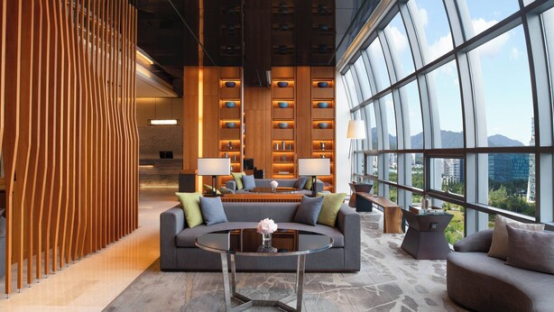 A modern lobby with a sofa, coffee table, and a reception desk.