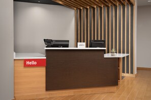 A reception desk with a 'Hello' sign, a computer, and a sign reading 'WATERSBORO BONVOY'. - TownePlace Suites by Marriott Cheyenne SW/Downtown Area (Cheyenne)