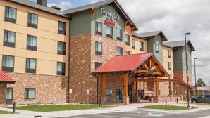 Ein TownePlace Suites Hotel mit Backsteinfassade, überdachtem Außenbereich und Parkplatz.