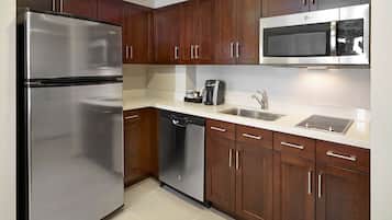 Una cocina moderna con armarios de madera, electrodomésticos de acero inoxidable y un microondas integrado.