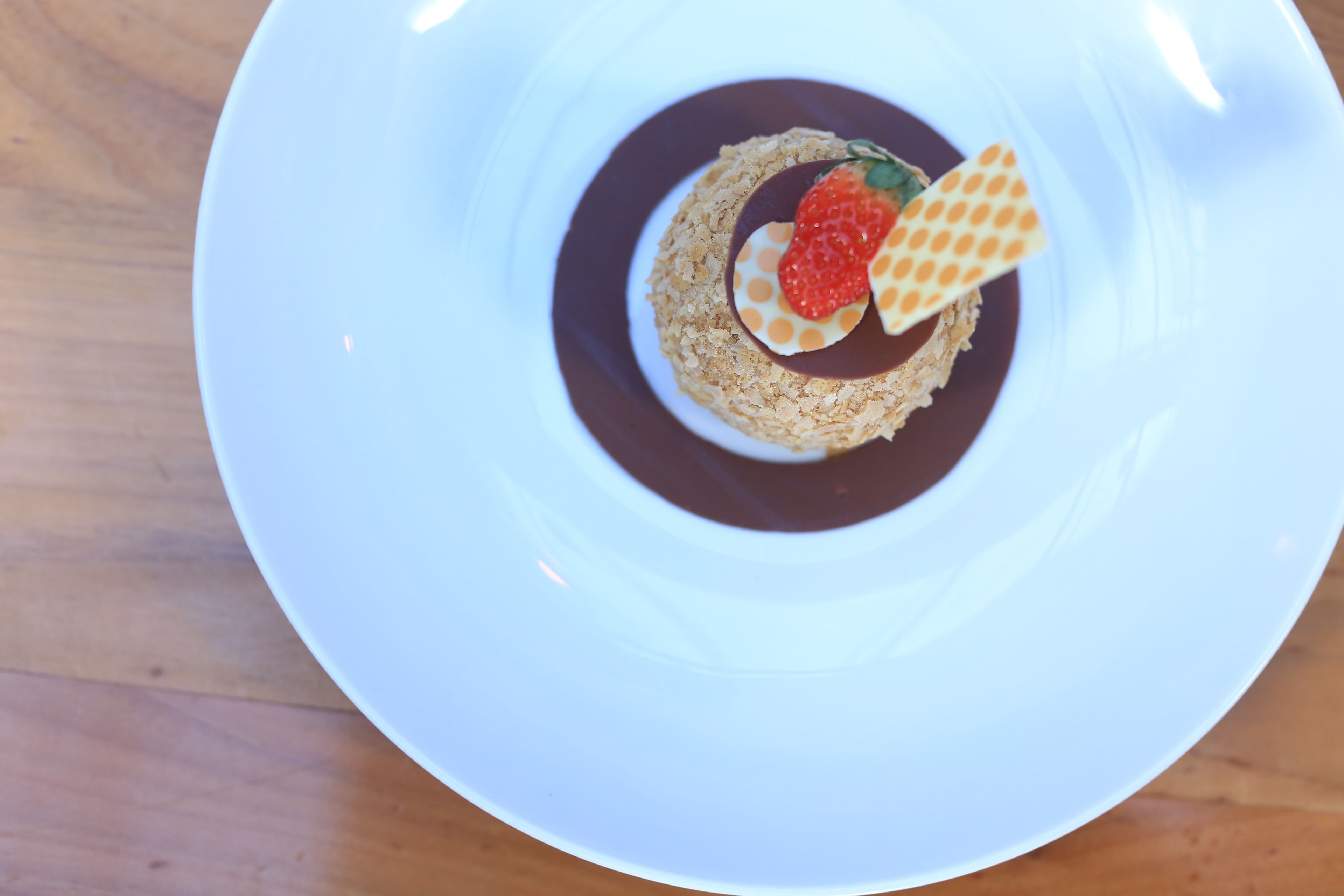 Dessert på en hvid tallerken med et træbord i baggrunden.