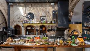 Un restaurante con pared de piedra, mesas de madera y una variedad de opciones de comida y bebida.
