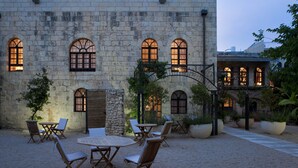 Un edificio de piedra con ventanas arqueadas y terraza.