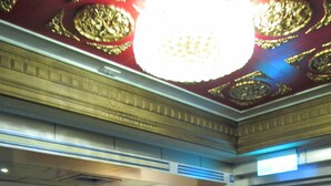 A room with a statue in a red alcove, a chandelier, and a door with a sign. - One Plus One Hotel (Taipei)