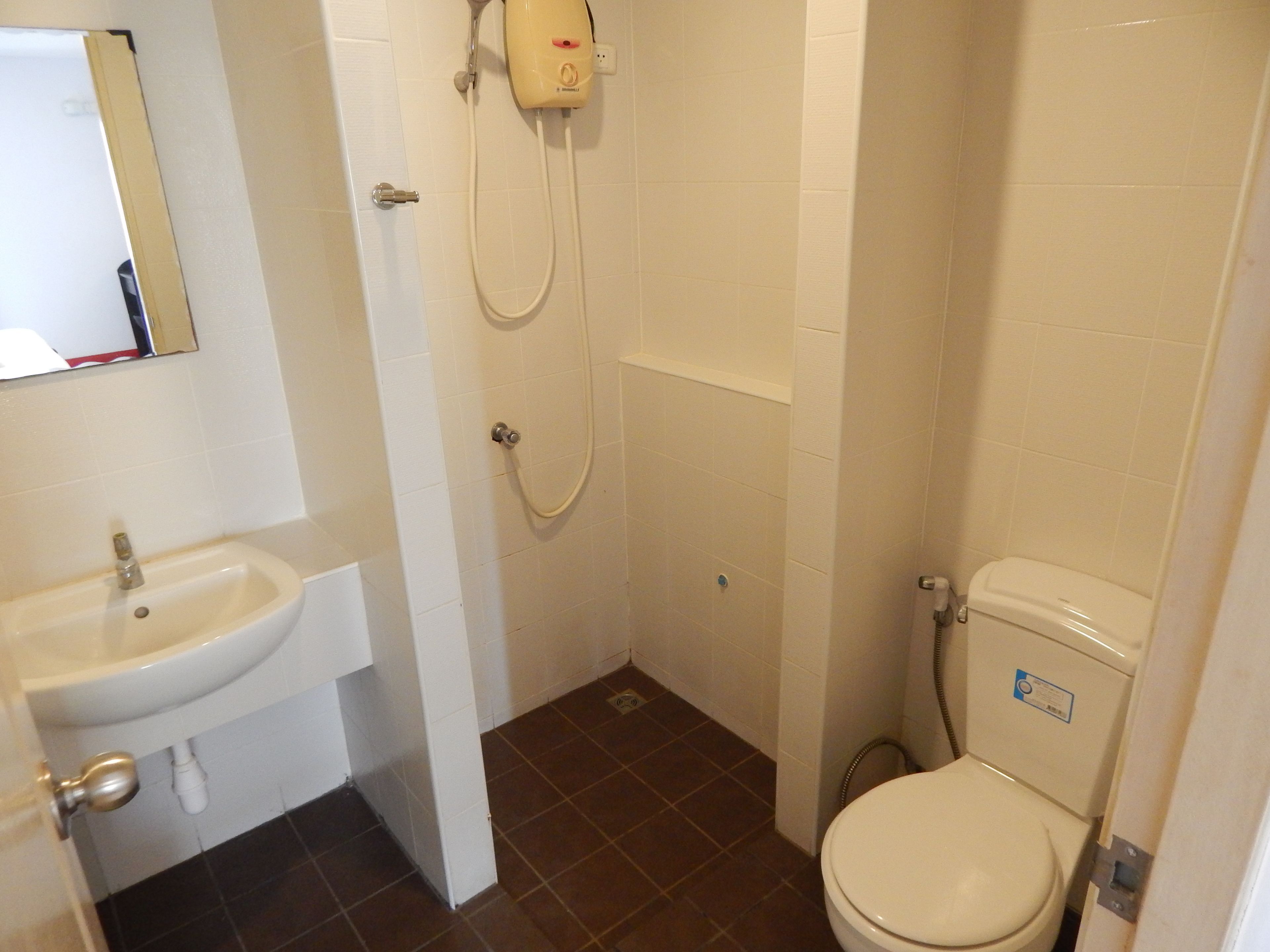 Un baño con lavamanos, inodoro y ducha.