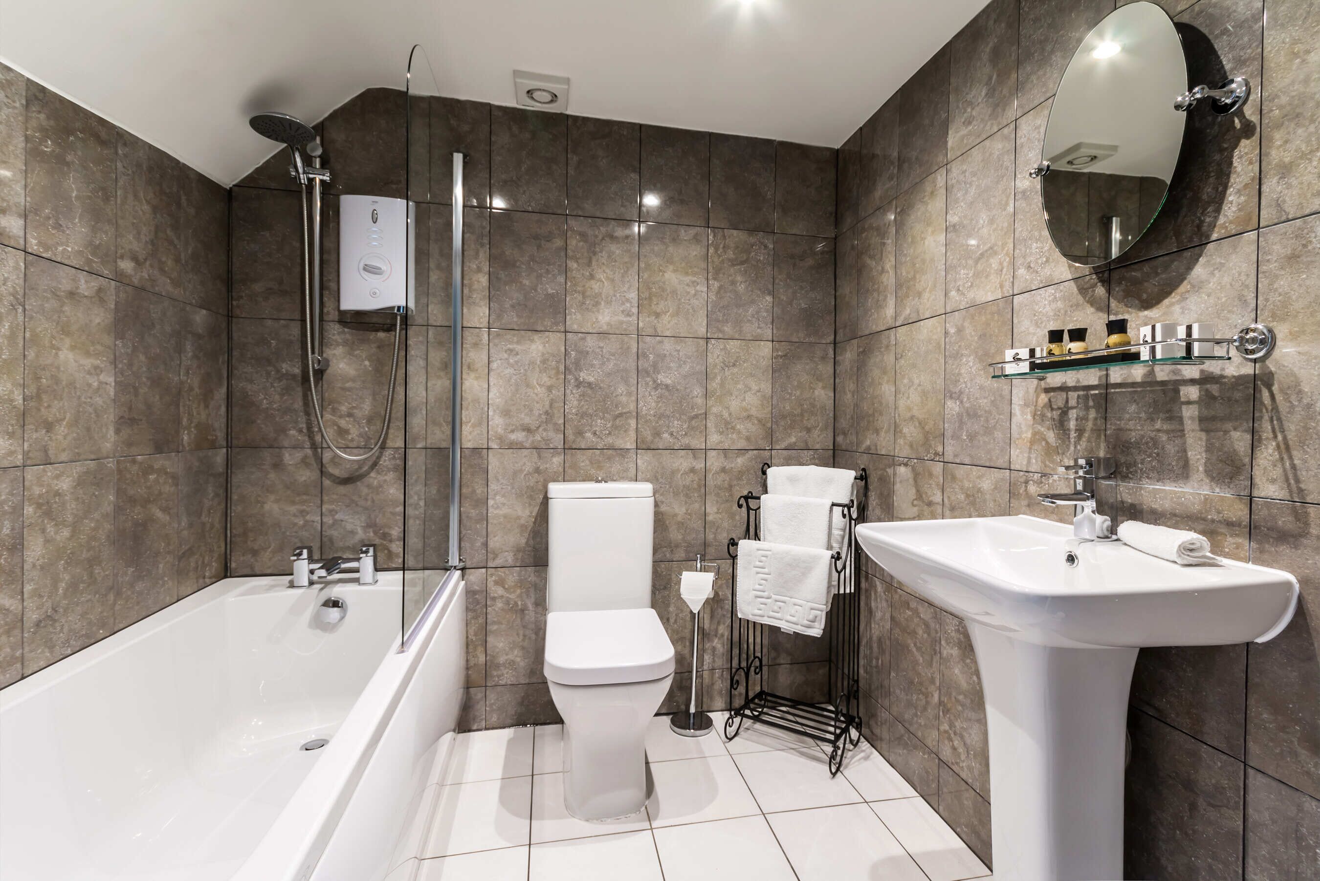 A modern bathroom with a bathtub, toilet, and sink.