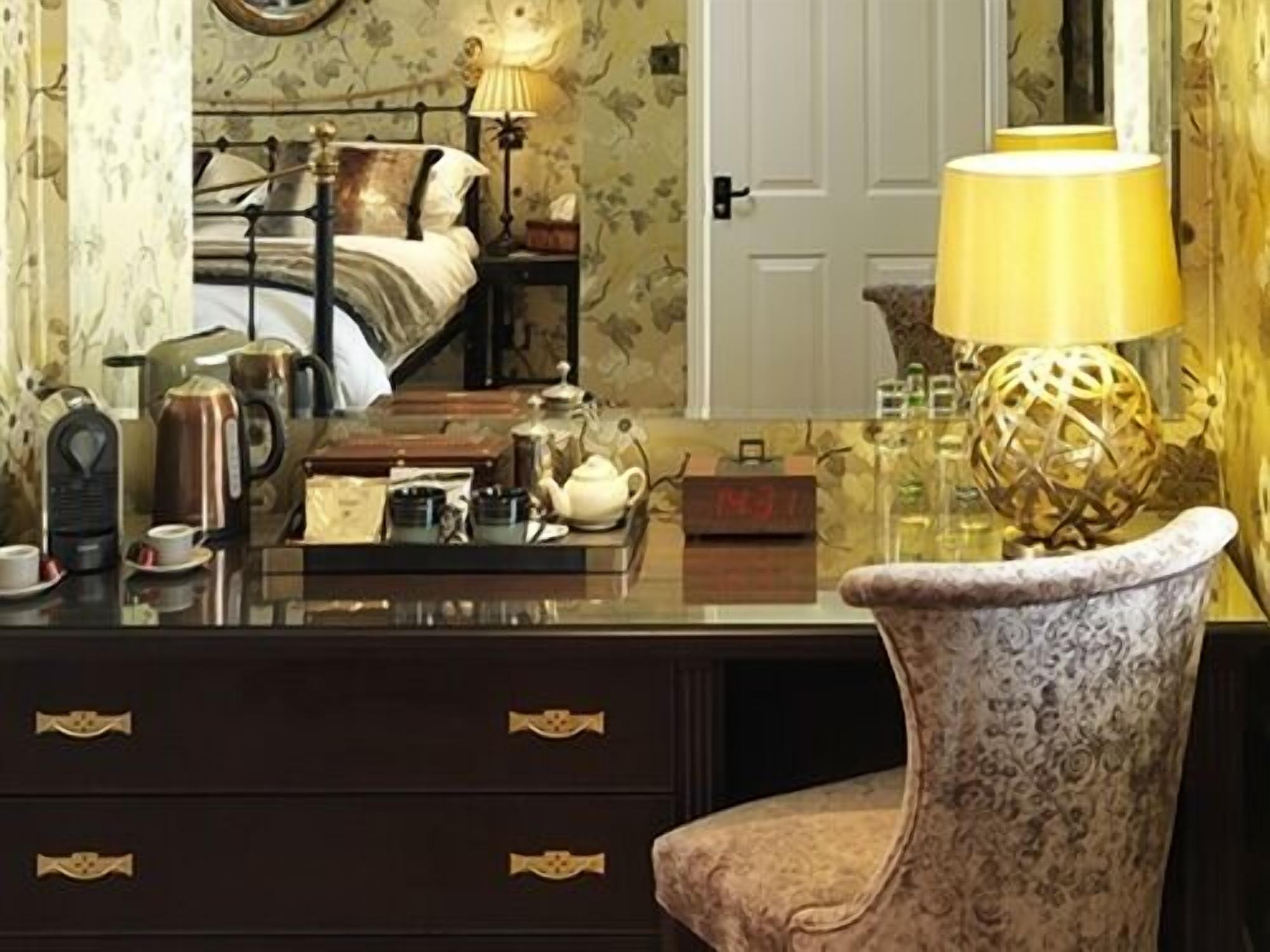 A bedroom with a bed, bedside table, lamp, and a dresser with drawers.