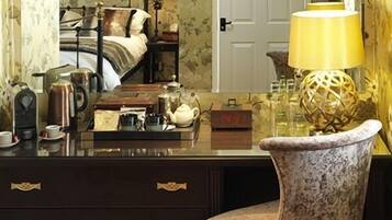 A bedroom with a bed, bedside table, lamp, and a dresser with drawers.
