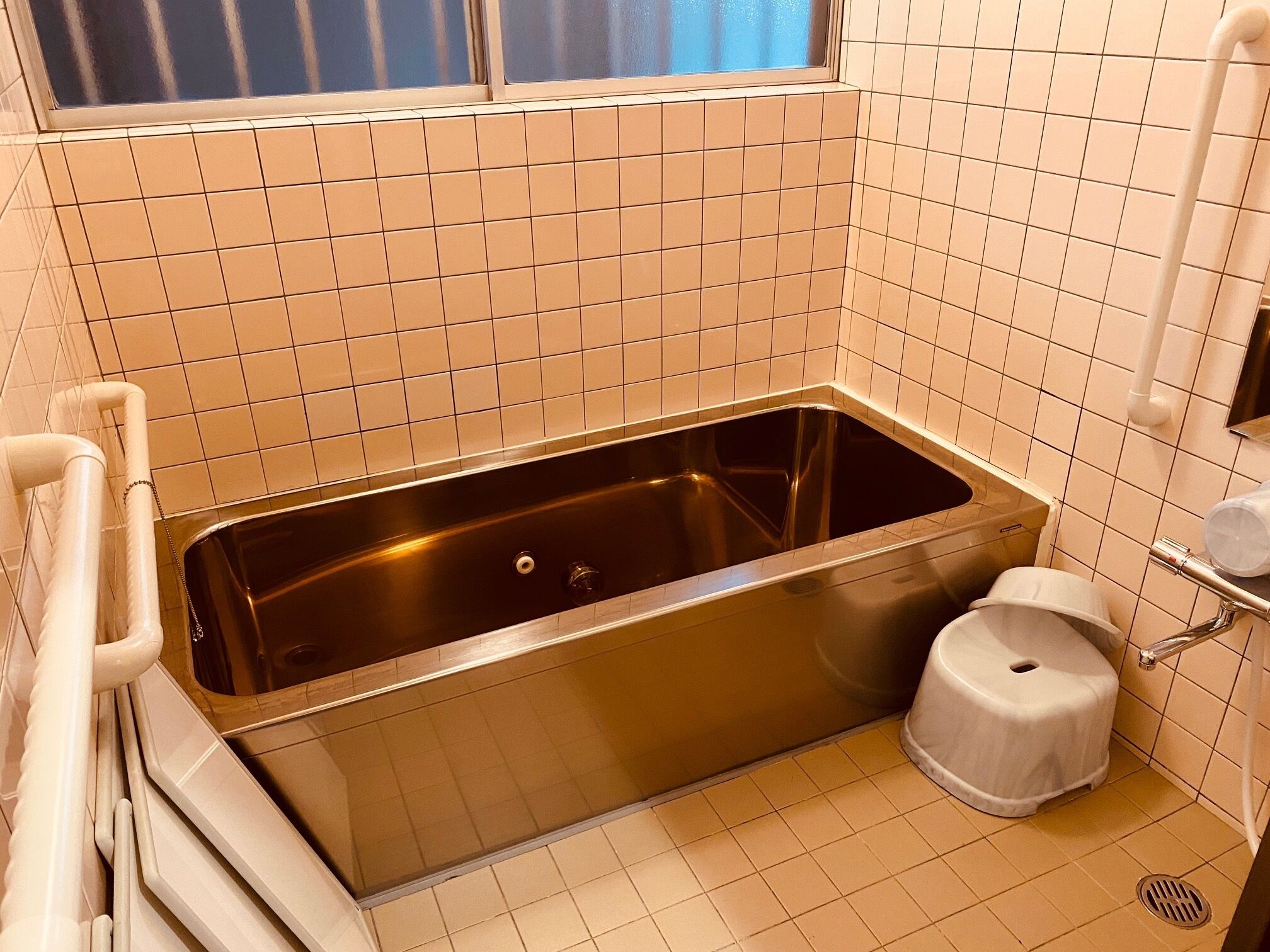 Un baño con bañera, inodoro y ventana.