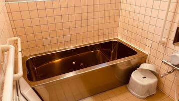 Un baño con bañera, inodoro y ventana.