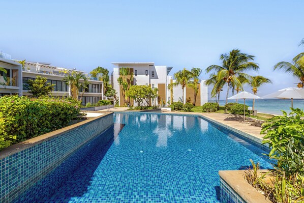 Alberca al aire libre, sombrillas en la alberca y camastros 