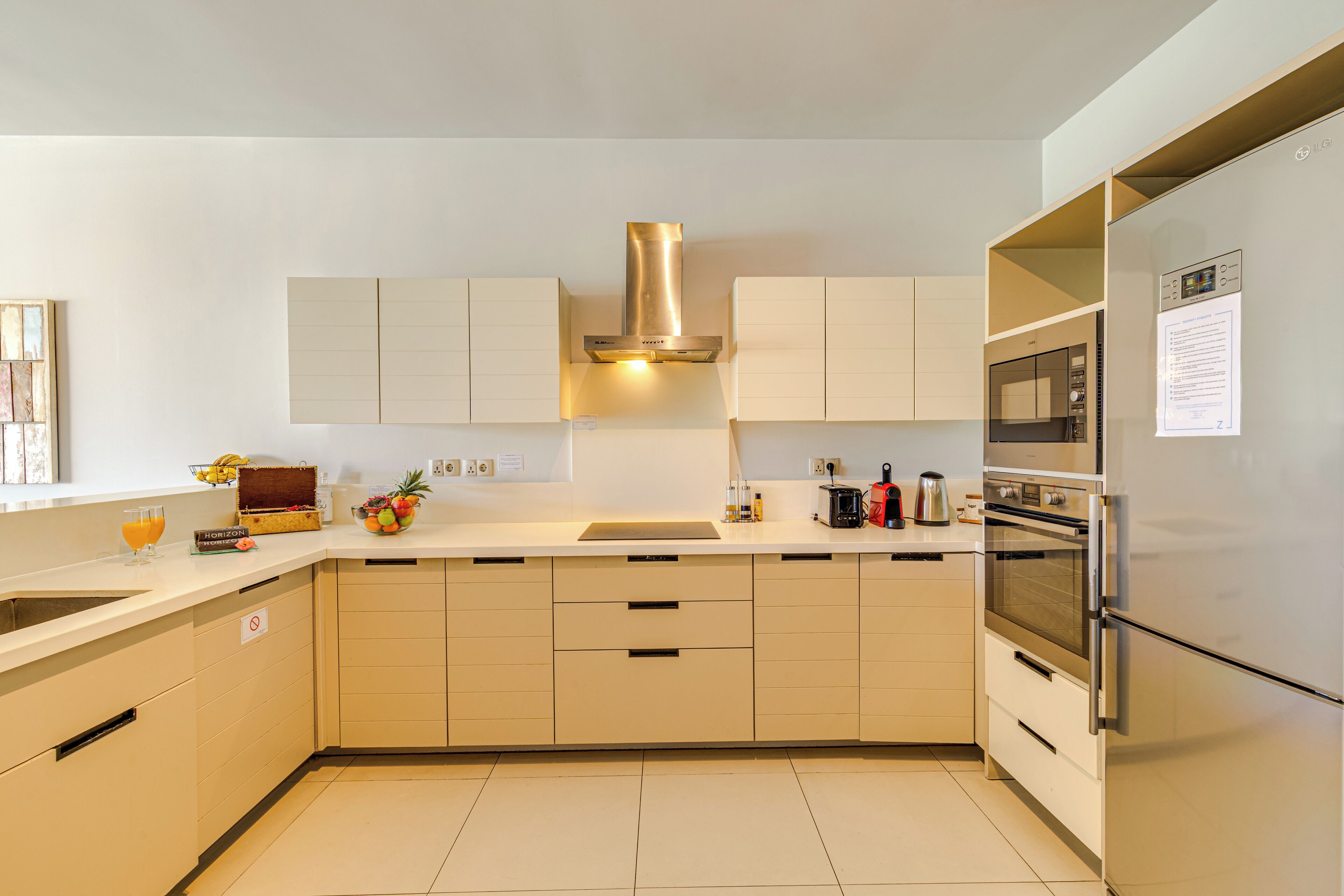 Una cocina moderna con armarios blancos, electrodomésticos de acero inoxidable y una isla central.