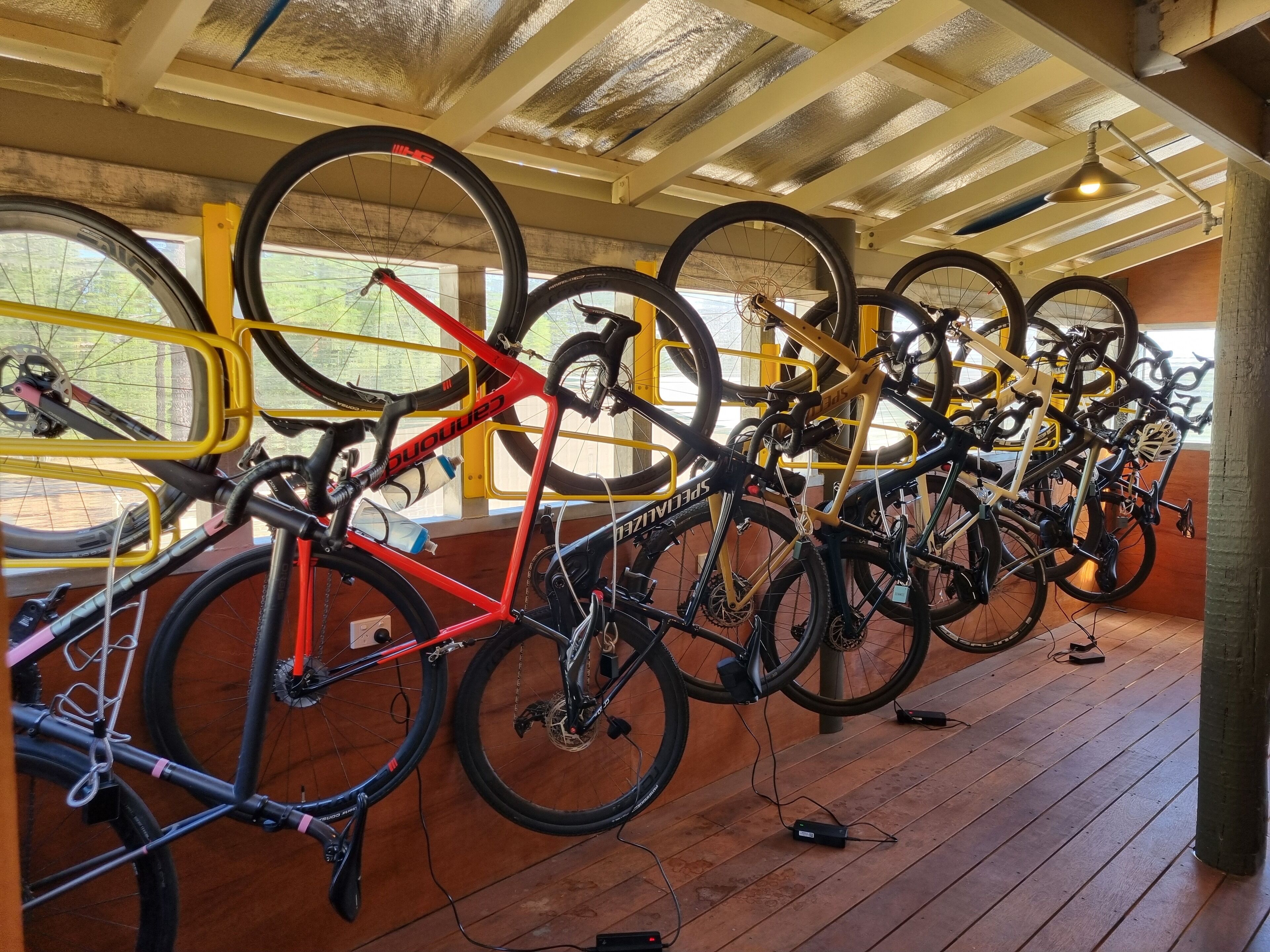 A bicycle storage area with multiple bikes secured on racks.