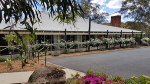 A building with a modern architectural style, featuring a flat roof and a brick chimney. - Golden Heritage Accommodation (Beechworth)