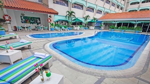 A swimming pool area with lounge chairs and a massage room. - Kartika Chandra (Jakarta)
