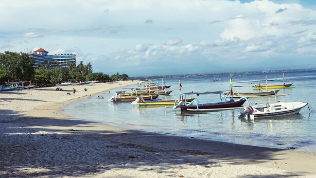 A beach with boats, a hotel, and a clear sky. - Patrisia Hotel Bali (Denpasar)
