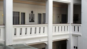 A multi-level building with white exterior walls and a balcony with a glass railing. - Ramayana Hotel (Makassar)