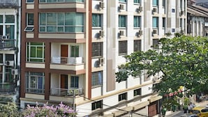 Ein mehrstöckiges Hotelgebäude mit Balkonen und Klimaanlagen.