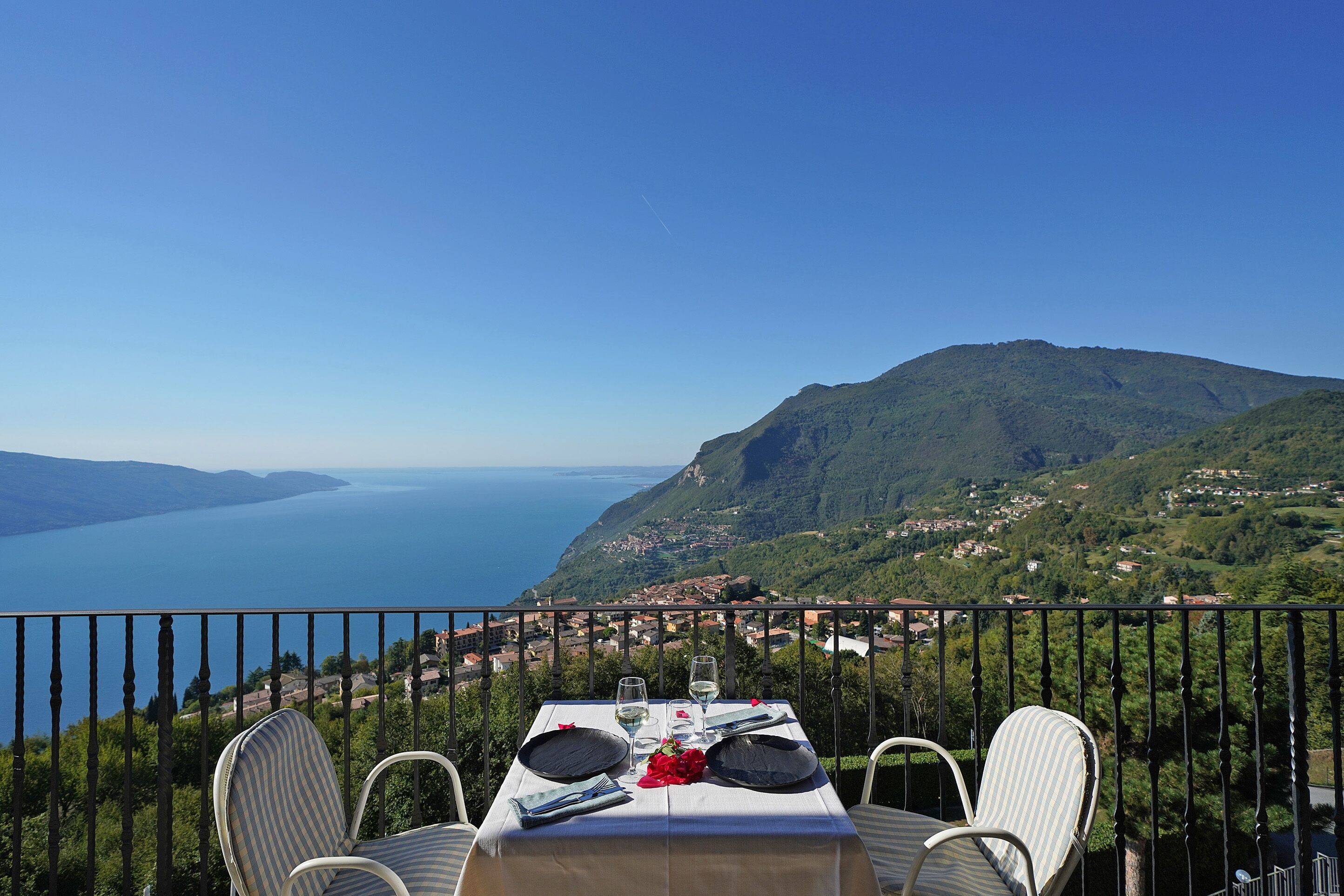 A table set for two with a scenic view of a lake and mountains.