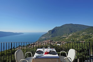 A table set for two with a scenic view of a lake and mountains.