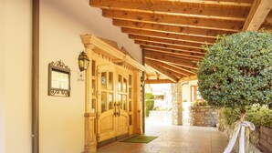 A wooden ceiling with a stone wall and a door with glass panels.