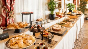 A buffet table with various pastries, desserts, and beverages.