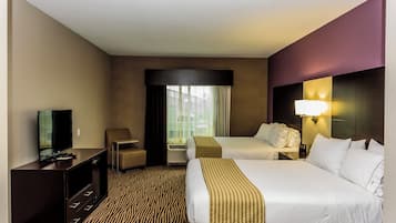 A hotel room with two beds, a TV, a desk, and a chair.
