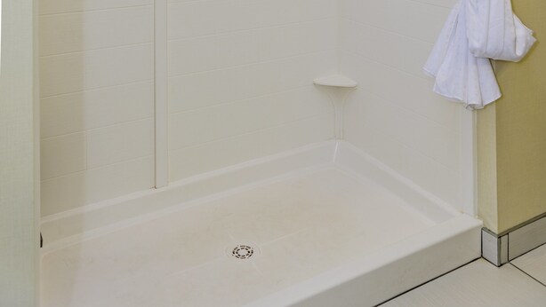 A walk-in shower with a glass door, a towel rack, and a showerhead. - Holiday Inn Express Cheektowaga North East by IHG (Buffalo)