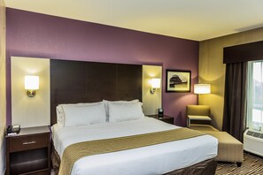 A hotel room with a large bed, two bedside tables, a chair, a lamp, and a picture on the wall. - Holiday Inn Express Cheektowaga North East by IHG (Buffalo)
