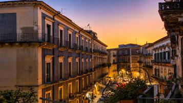 Un vicolo stretto fiancheggiato da edifici con balconi, sotto un cielo al tramonto.