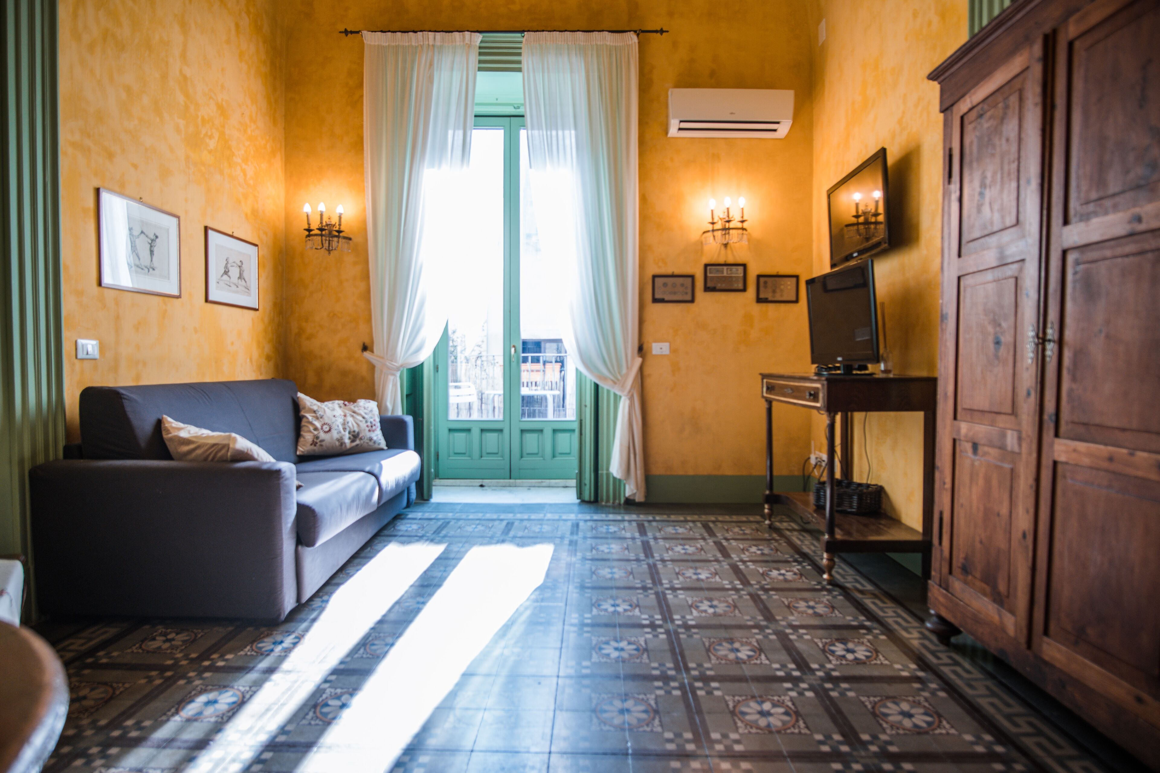 Una habitación con sofá, televisión y un armario.