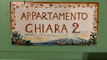 Schild für 'APARTAMENTO GHIARA 2' mit Illustration einer Berglandschaft.