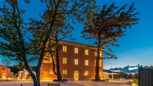 A multi-story building with a symmetrical facade, large windows, and a central entrance. - Relais Paradiso (Gualdo Cattaneo)