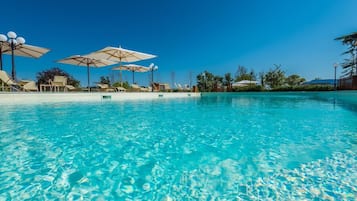 Een seizoensgebonden buitenzwembad, parasols voor strand/zwembad