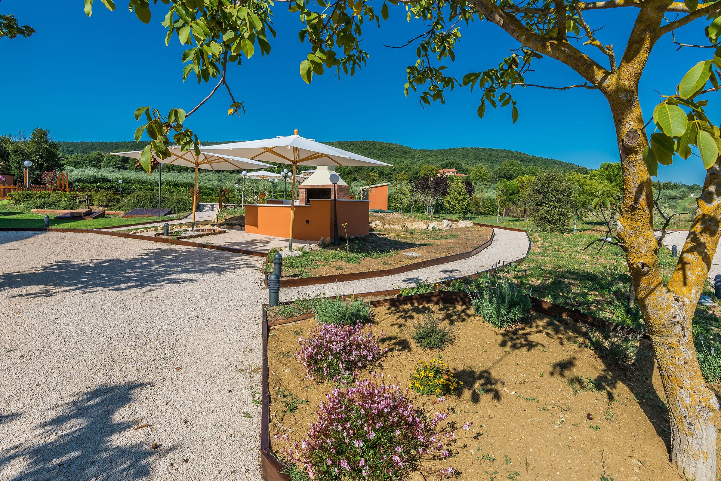 Un espace extérieur aménagé avec un barbecue, des sièges et une vue sur le paysage environnant.