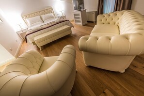 Une chambre à coucher moderne avec un lit, un canapé et un fauteuil aux lignes courbes.