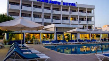 Experience the hotel's modern design and pool area with lounge chairs and umbrellas.