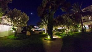 A nighttime outdoor area with a pathway, trees, and a building in the background. - Marathon Beach Resort (Marathon)