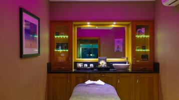 Une chambre d’hôtel équipée d’un lit, d’un grand miroir, d’un lavabo et d’une coiffeuse avec des articles de toilette.