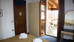 Un dormitorio con cama, armario y escritorio.