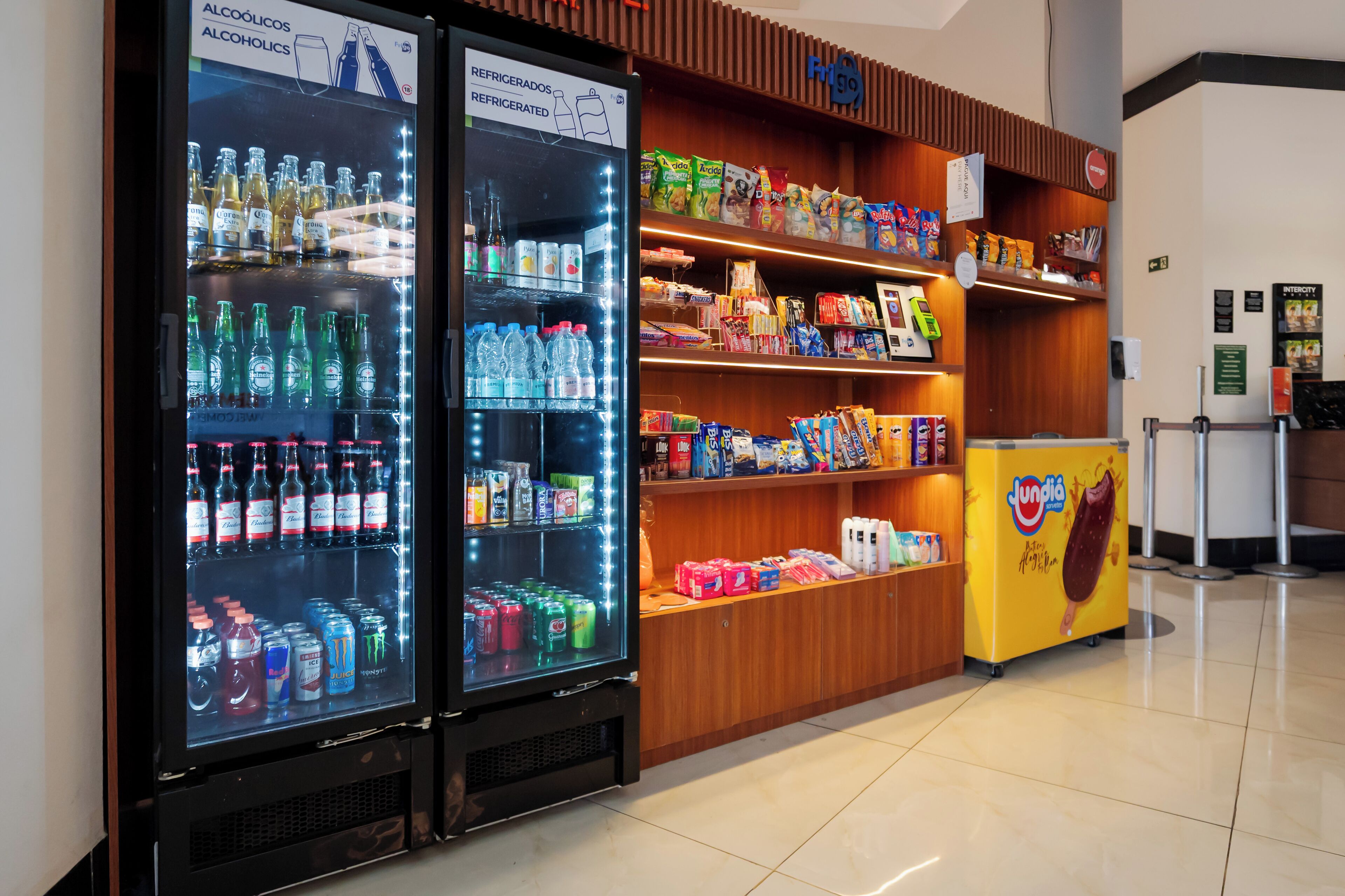 Un espace de vente proposant des distributeurs automatiques de boissons réfrigérées et des présentoirs de snacks.