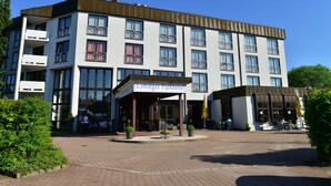 A modern hotel with a covered entrance, multiple balconies, and outdoor seating areas. - Lobinger Hotel Parkhotel (Giengen an der Brenz)