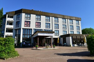 Un hôtel moderne doté d’une entrée couverte, de nombreux balcons et d’espaces de détente en plein air.
