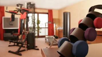 A home gym with exercise equipment, a punching bag, and dumbbells.
