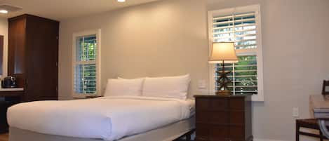 A bedroom with a bed, a dresser, and a lamp.