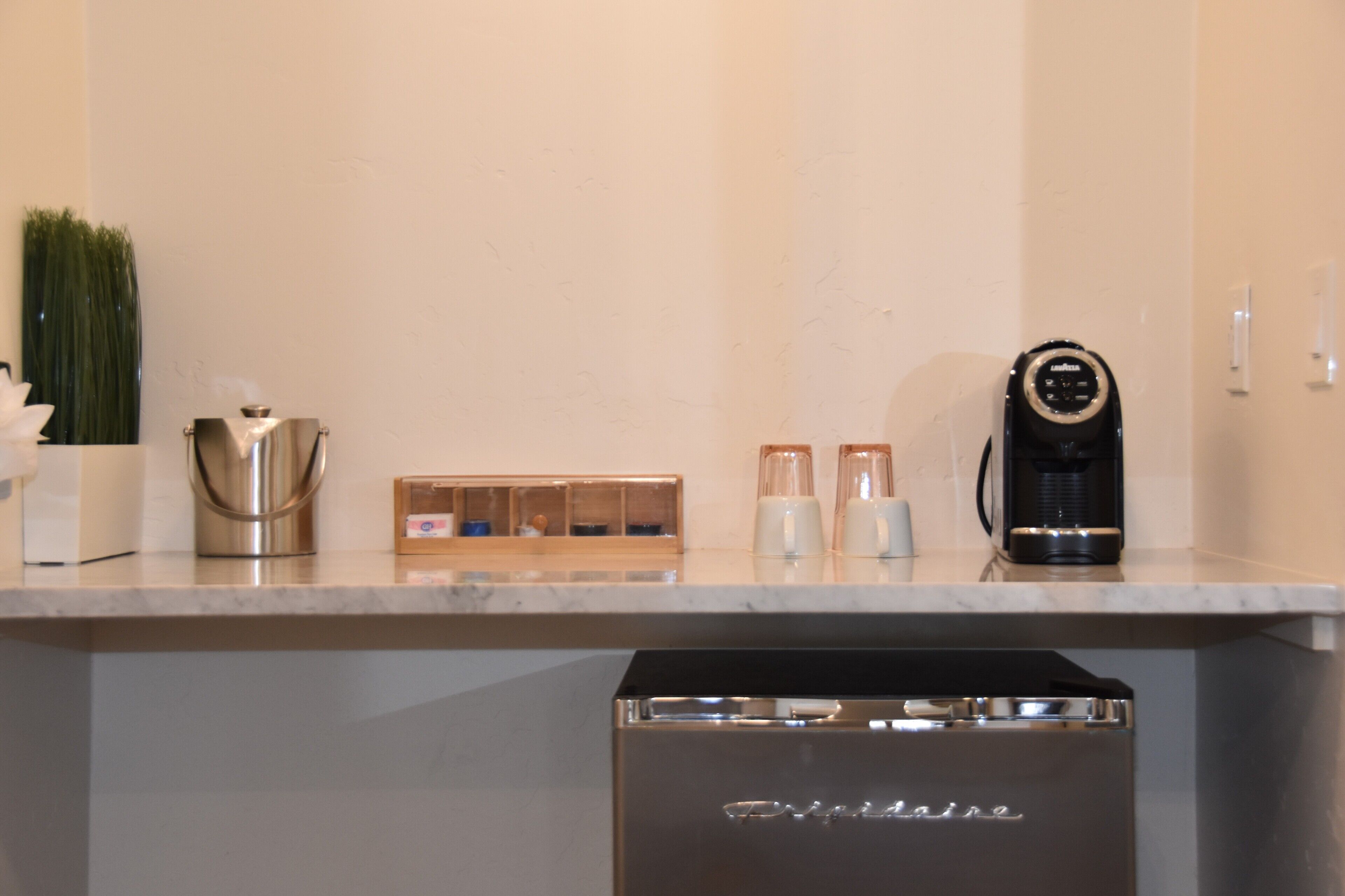 A kitchen with a coffee maker, a blender, and a dishwasher.