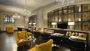A spacious lobby with a high ceiling, ornate chandeliers, and a seating area with sofas and armchairs. - Magnolia Hotel St. Louis, a Tribute Portfolio Hotel (St. Louis)